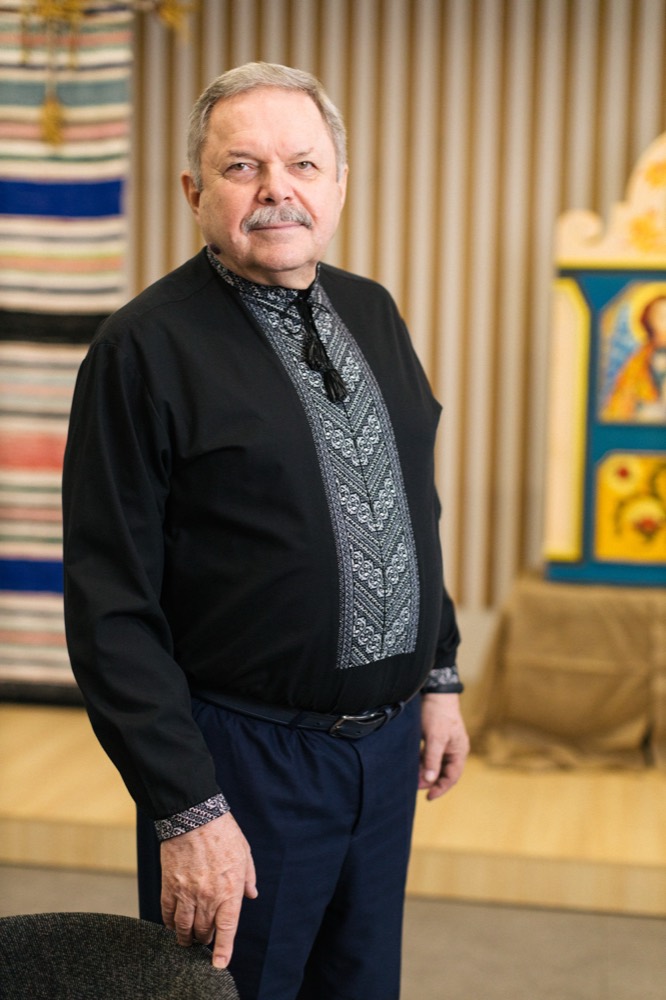 Myroslav Marynovych in an embroidered shirt before a Ukrainian icon.